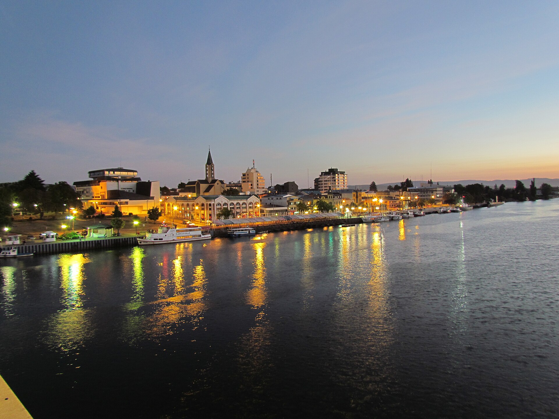 Río Valdivia al atardecer con la costanera iluminada